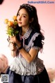 A woman holding a bunch of flowers in her hand.