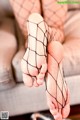 A close up of a woman's feet in fishnet stockings.