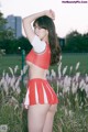 A woman in a red and white cheerleading uniform posing for a picture.