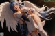 Anime girl with blue hair and white wings holding a sword.