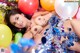 A woman laying on top of a pile of balloons.