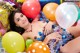 A woman laying on top of a pile of balloons.