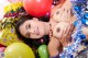 A woman laying on top of a pile of balloons.