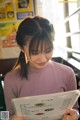 A woman sitting at a table reading a menu.