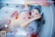 A woman laying in a bathtub covered in plastic.