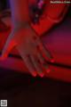 A person's hand is lit up in red light.