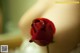 A single red rose sitting on top of a table.