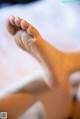 A close up of a person's foot on a bed.