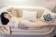 A woman laying on a white couch in lingerie.